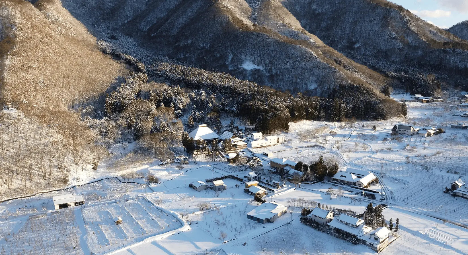 一面の雪に覆われた長野県小布施町の山間にたたずむ岩松院。白銀の集落に赤い屋根が映える