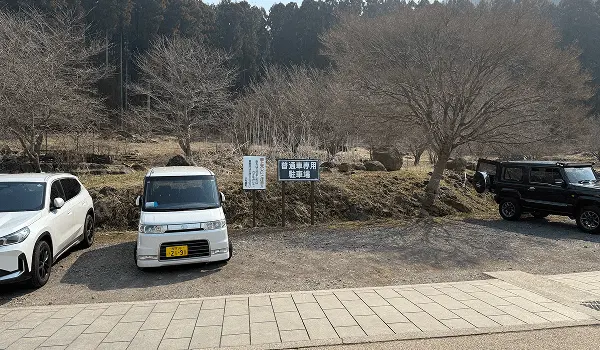 岩松院の専用駐車場、普通車数台が駐車可能で山間の自然に囲まれた駐車スペース